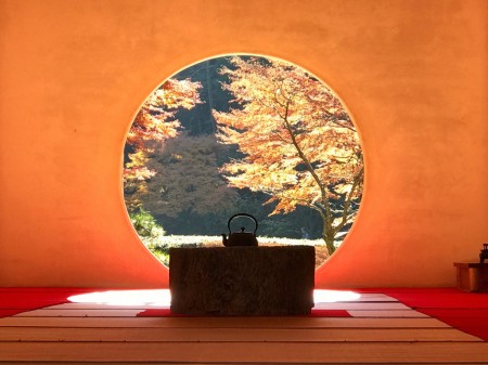 Circular window in the main hall(Hojo) with autumn leaves at Meigetsuin in Kamakura